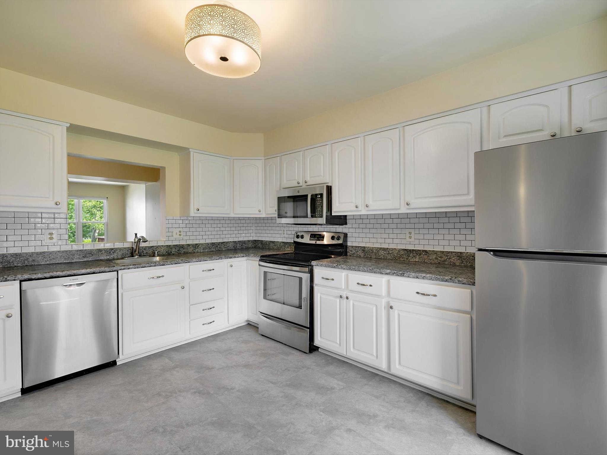 2846 Schoolhouse Circle Silver Spring, MD 20902 - Photo 10 of 32 a kitchen with granite countertop white cabinets white stainless steel appliances and a refrigerator