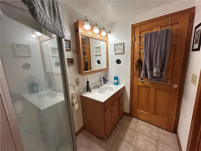 a bathroom with sink a mirror a bathtub and shower