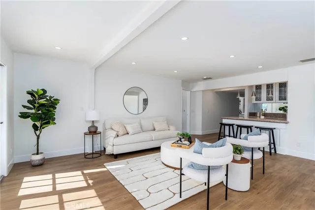 a living room with furniture a chandelier and a potted plant