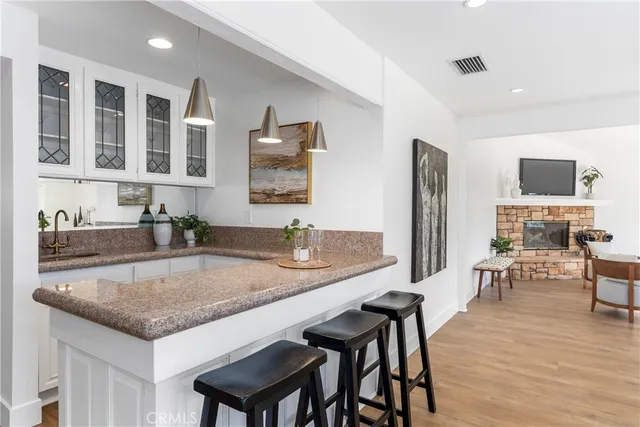 a kitchen with granite countertop a table chairs microwave and sink