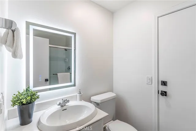 a bathroom with a sink mirror and toilet