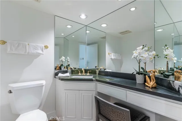 a bathroom with a sink a toilet and mirror