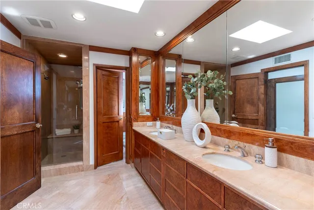 a bathroom with double vanity and a mirror