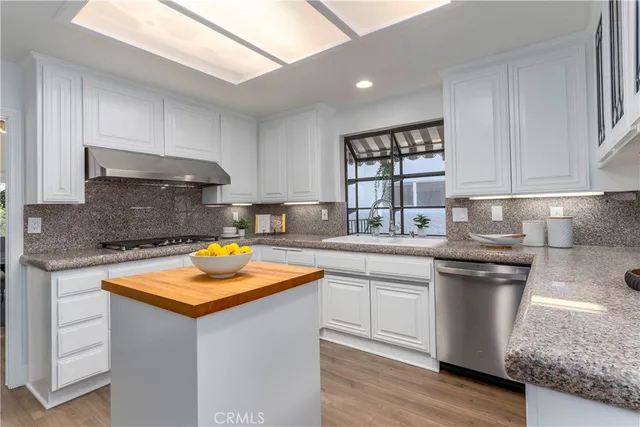 a kitchen with stainless steel appliances granite countertop a sink stove and cabinets