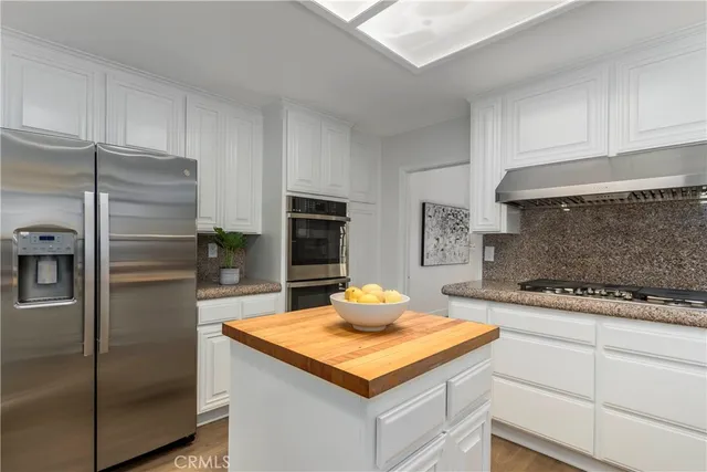 a kitchen with granite countertop a sink and refrigerator
