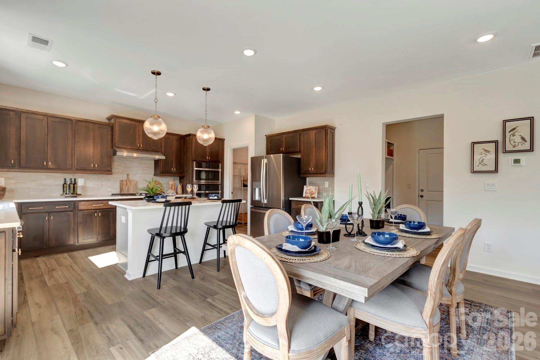 1458 Kate Cecil Way York, SC 29745 - Photo 11 of 40 a kitchen with stainless steel appliances kitchen island granite countertop a dining table chairs and a refrigerator
