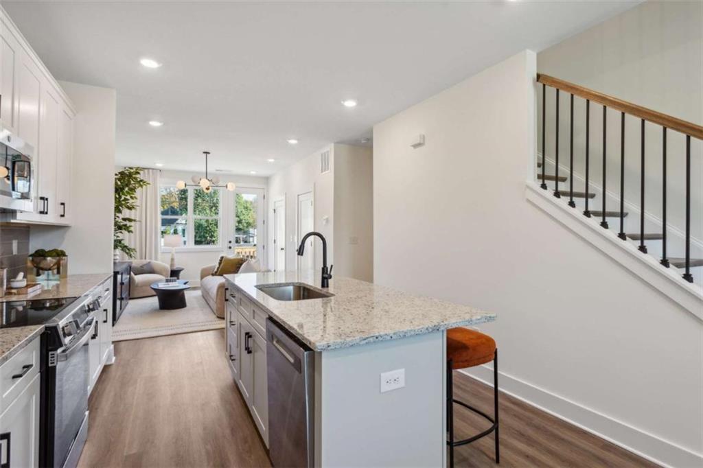 103 Mission Way Atlanta, GA 30315 - Photo 12 of 18 a kitchen with stainless steel appliances granite countertop a sink stove and wooden floor