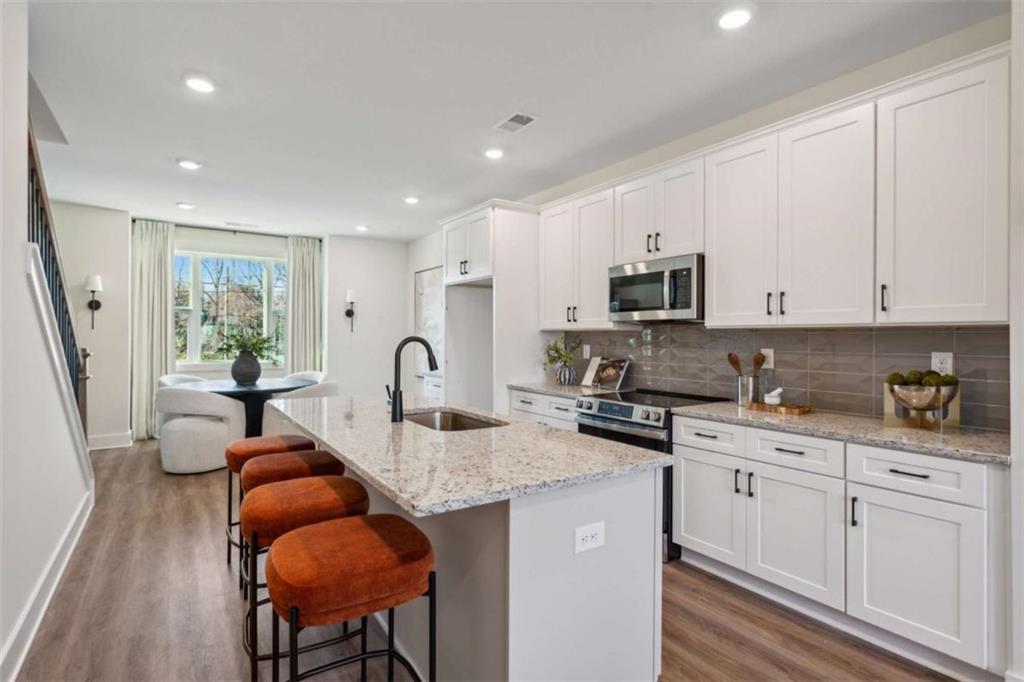 103 Mission Way Atlanta, GA 30315 - Photo 14 of 18 a open kitchen with granite countertop a stove a sink a dining table and chairs