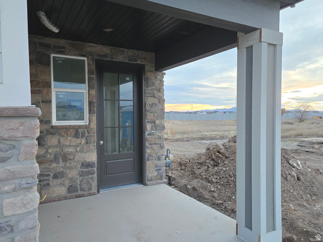 1661 West Ross Road Syracuse, UT 84075 - Photo 2 of 28 Property entrance featuring stone siding and a patio area