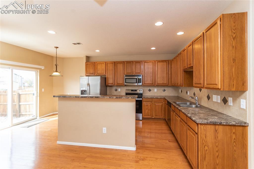 4829 Harrier Ridge Drive Colorado Springs, CO 80916 - Photo 11 of 50 a kitchen with granite countertop a sink a counter top space stainless steel appliances and cabinets