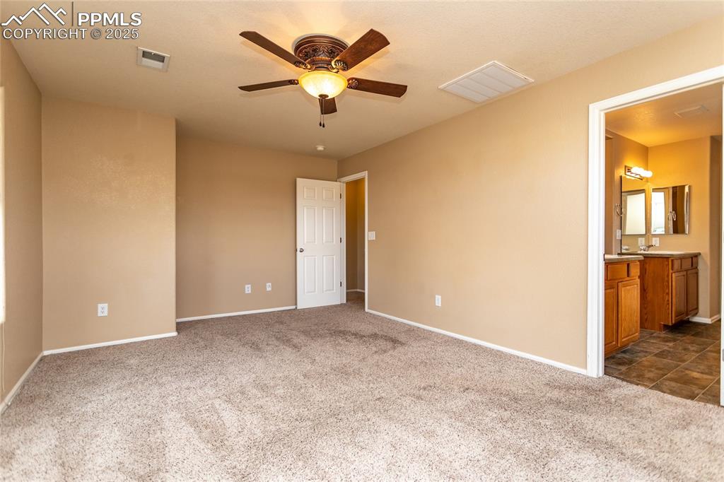 4829 Harrier Ridge Drive Colorado Springs, CO 80916 - Photo 28 of 50 an empty room with a bathroom and a chandelier fan