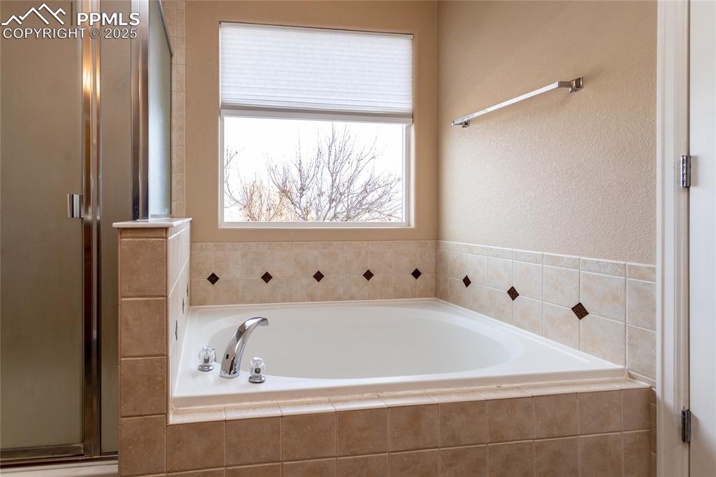 4829 Harrier Ridge Drive Colorado Springs, CO 80916 - Photo 33 of 50 a bathroom with bathtub and window