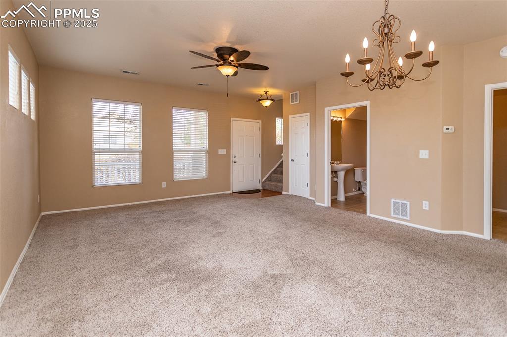 4829 Harrier Ridge Drive Colorado Springs, CO 80916 - Photo 6 of 50 a view of a livingroom with a chandelier fan and windows