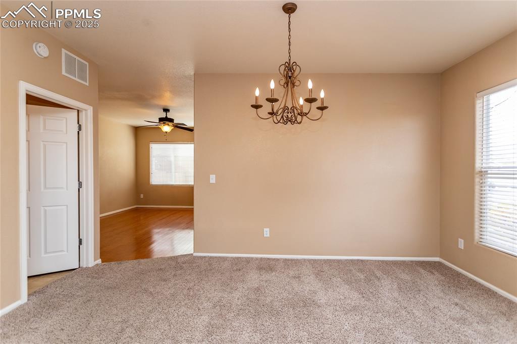 4829 Harrier Ridge Drive Colorado Springs, CO 80916 - Photo 7 of 50 an empty room with chandelier and windows
