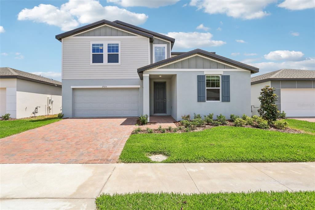 a front view of a house with a yard and garage