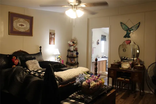 a living room with furniture a ceiling fan and a flat screen tv