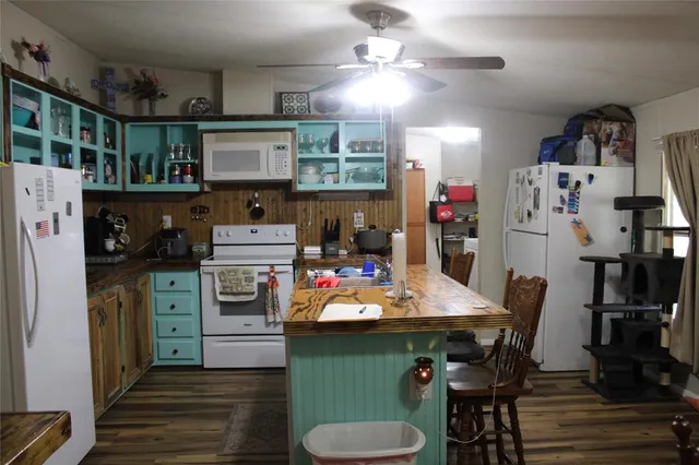 a kitchen with a sink stove and a dining table with chairs