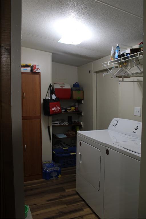 7901 County Road 620 Blanket, TX 76432 - Photo 26 of 34 Laundry area featuring washer / clothes dryer, dark wood-style floors, and a textured ceiling