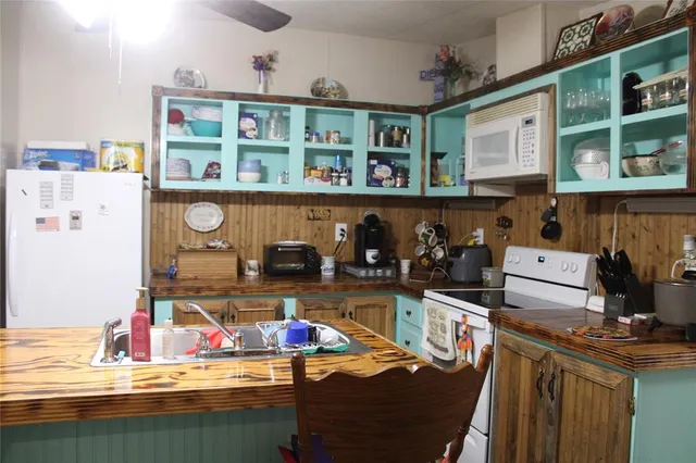 a room with stainless steel appliances a dining table and chairs