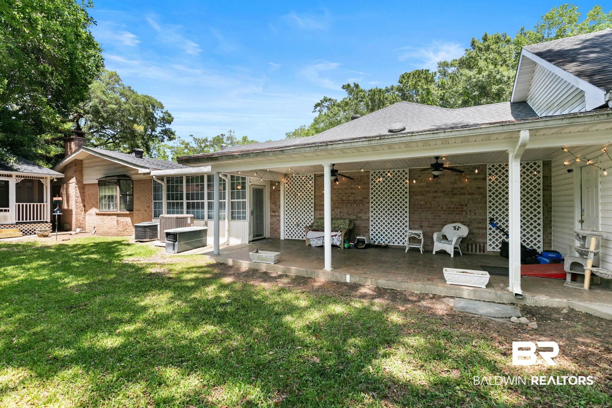 927 Cleveland Road Saraland, AL 36571 - Photo 60 of 80 Expansive covered patio featuring ceiling fans, string lighting, and lattice privacy screens