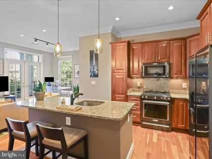 a kitchen with stainless steel appliances granite countertop a stove a sink a microwave a dining table and chairs