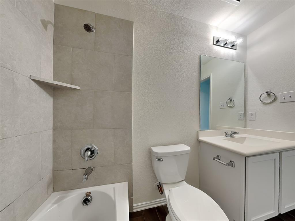 506 Robinson Way Fate, TX 75189 - Photo 24 of 30 Bathroom with a textured wall, vanity, shower / bath combination, and dark wood-style floors