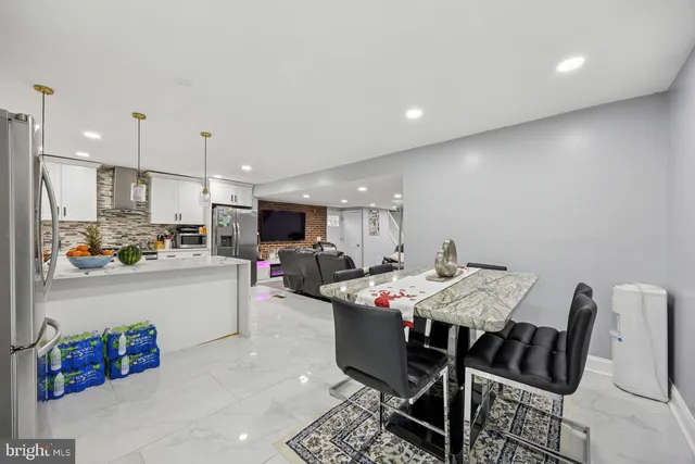 a kitchen with stainless steel appliances kitchen island granite countertop a sink table and chairs