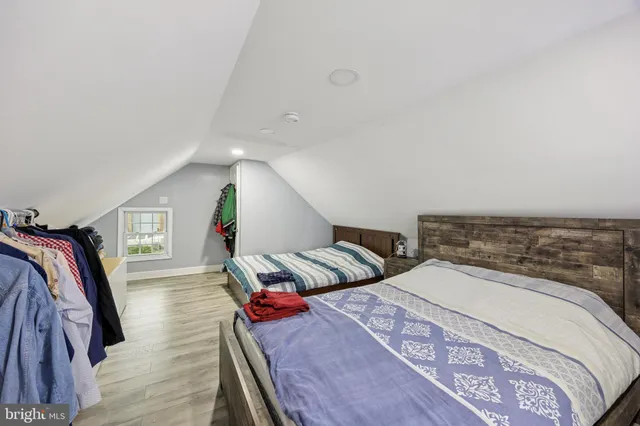 a bedroom with two beds and wooden floor