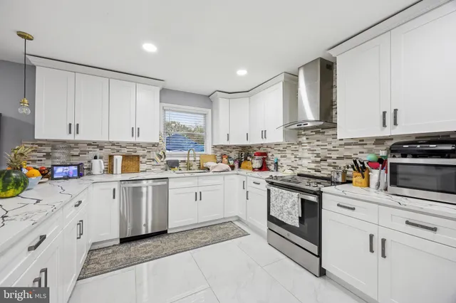 a kitchen with granite countertop white cabinets and white appliances