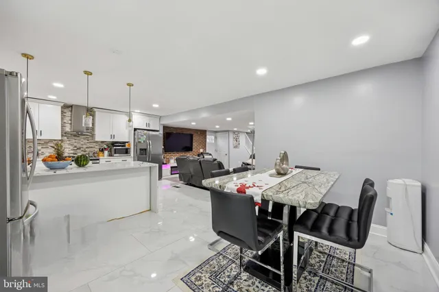a kitchen with a dining table chairs and refrigerator