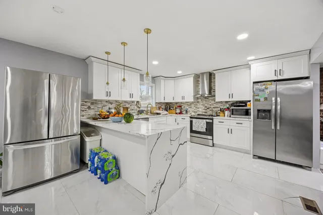a kitchen with white cabinets stainless steel appliances and refrigerator