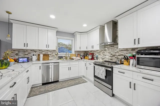 a kitchen with granite countertop white cabinets and white appliances