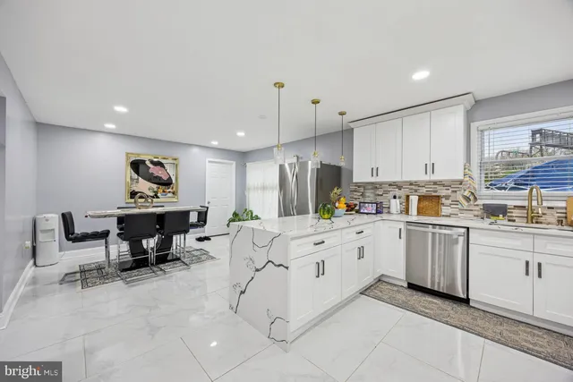 a kitchen with white cabinets a table and chairs