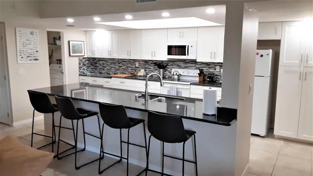 a kitchen with stainless steel appliances kitchen island granite countertop a sink and cabinets