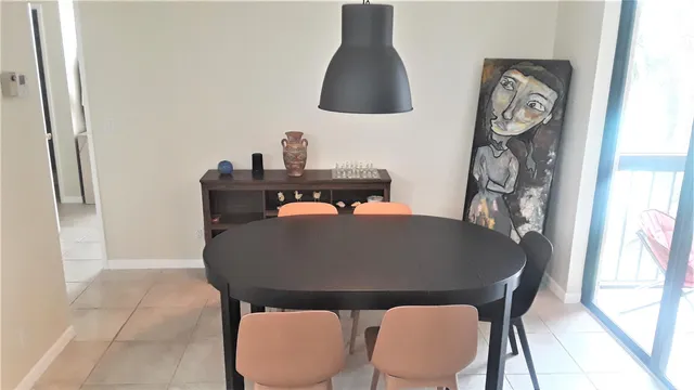 a table with a chair a lamp and a window