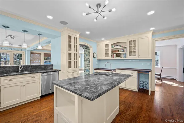 a kitchen with granite countertop center island wooden floor and stainless steel appliances