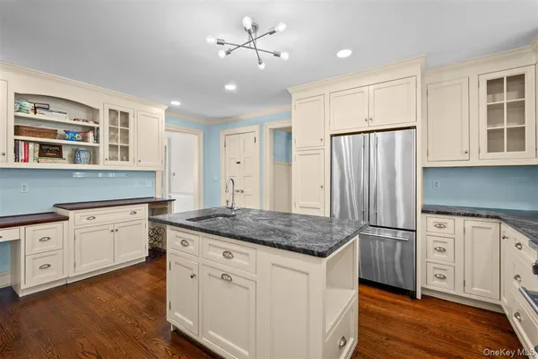 a kitchen with stainless steel appliances granite countertop a stove refrigerator and cabinets