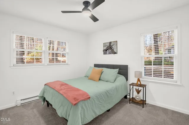 a bedroom with a bed a dresser and a window