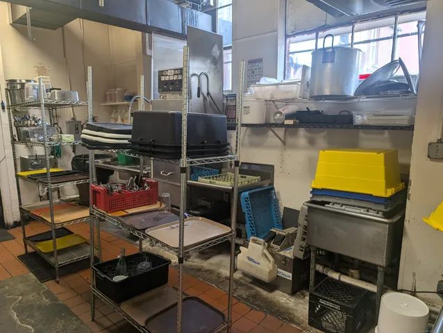 a room with stainless steel appliances kitchen island granite countertop a stove and a sink