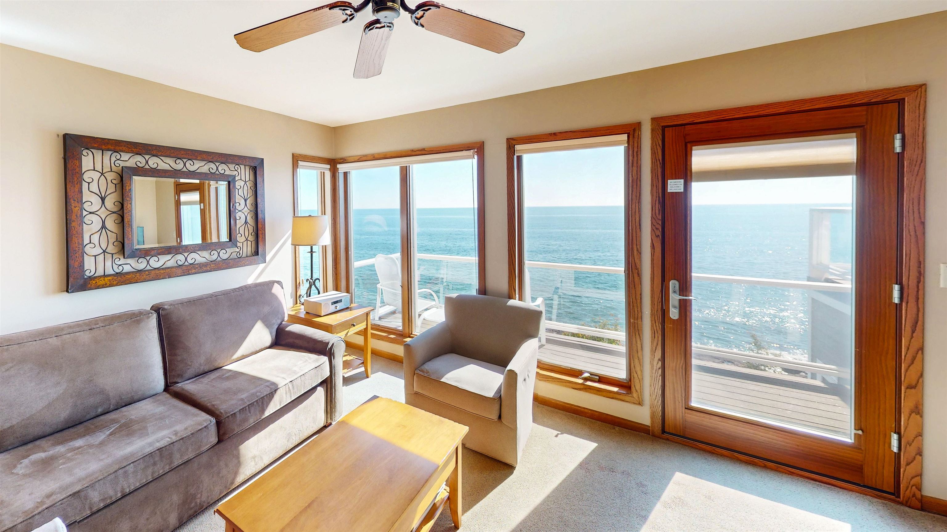 7192 Highway 61, Unit 37 Tofte, MN 55615 - Photo 4 of 15 Living room featuring a water view, light carpet, and ceiling fan