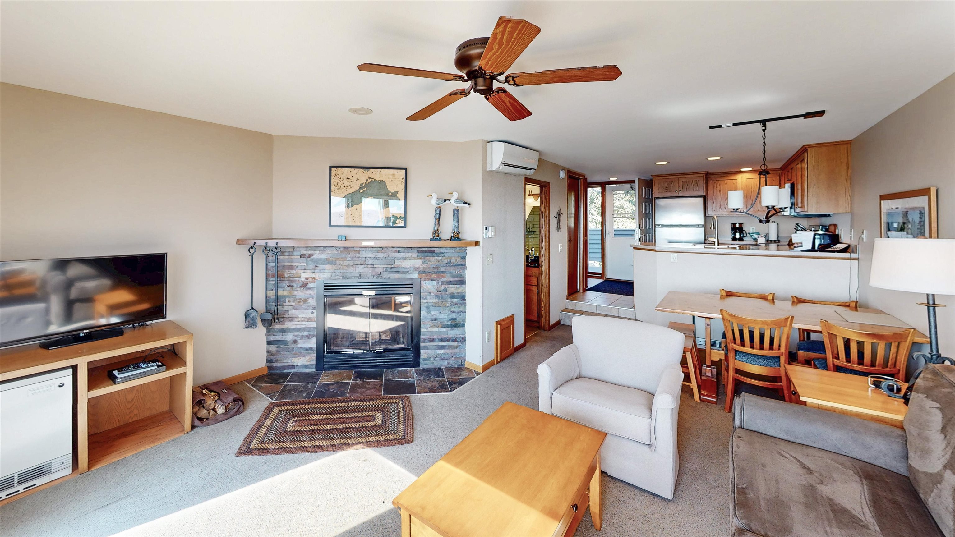 7192 Highway 61, Unit 37 Tofte, MN 55615 - Photo 6 of 15 Living room with a fireplace, ceiling fan, light colored carpet, a wall unit AC, and recessed lighting
