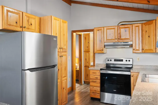 a kitchen with stainless steel appliances granite countertop a sink and cabinets with wooden floor