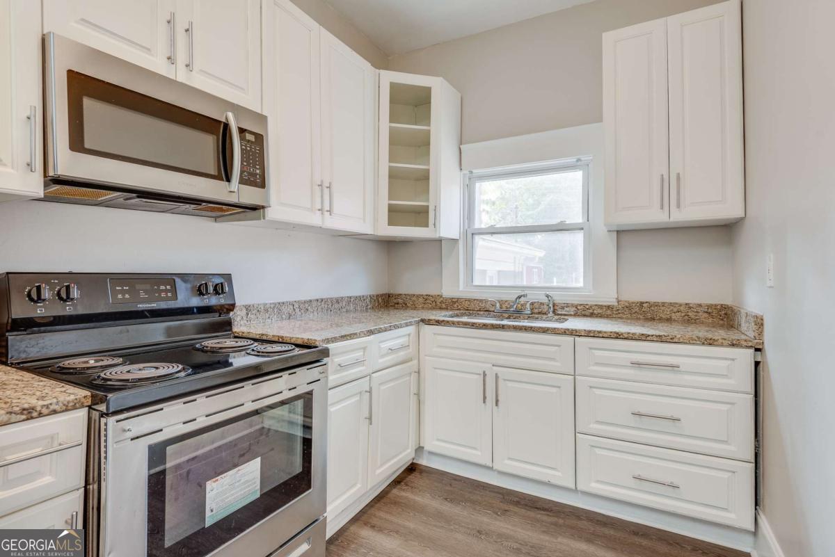 1330 Allene Avenue Southwest Atlanta, GA 30310 - Photo 5 of 24 a kitchen with granite countertop white cabinets stainless steel appliances and a window