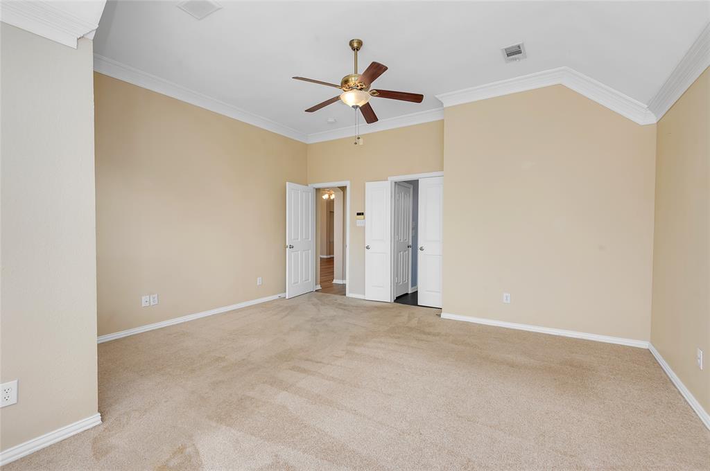 1404 Ranch Hill Drive Irving, TX 75063 - Photo 25 of 31 Spacious room featuring vaulted ceilings, crown molding, a ceiling fan, and plush carpeting