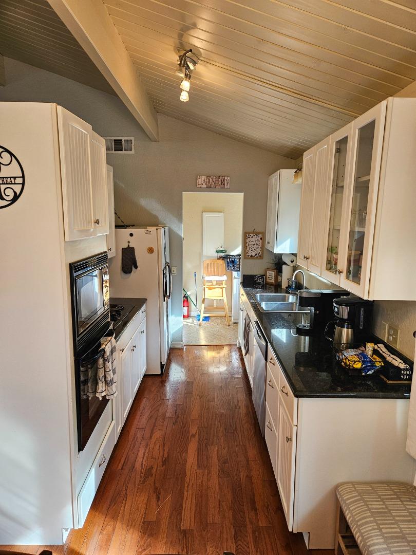 19418 Ferretti Road Groveland, CA 95321 - Photo 6 of 35 a kitchen with granite countertop a stove a sink dishwasher and a refrigerator