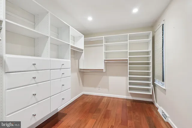 a view of walk in closet with empty racks