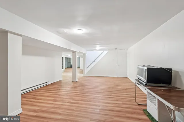 a spacious bedroom with a bed and wooden floor