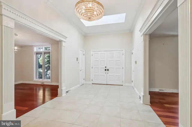 a view of a hallway to a bedroom with wooden floor and a ceiling fan