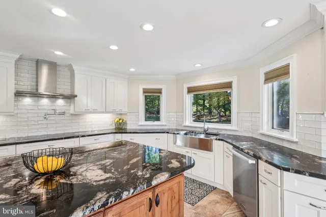 a large kitchen with stainless steel appliances granite countertop a sink a stove a counter space and cabinets