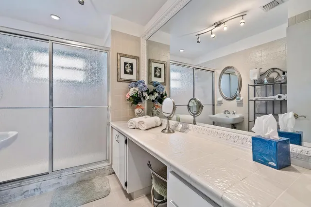 a large bathroom with a double vanity sink a mirror and a shower
